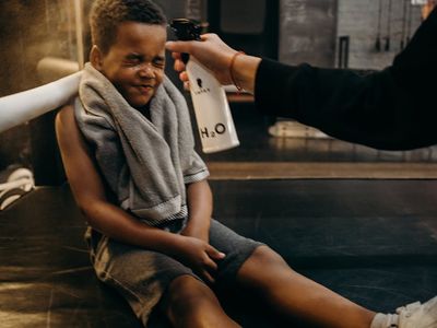 Sports bottle and towel on a dark bench